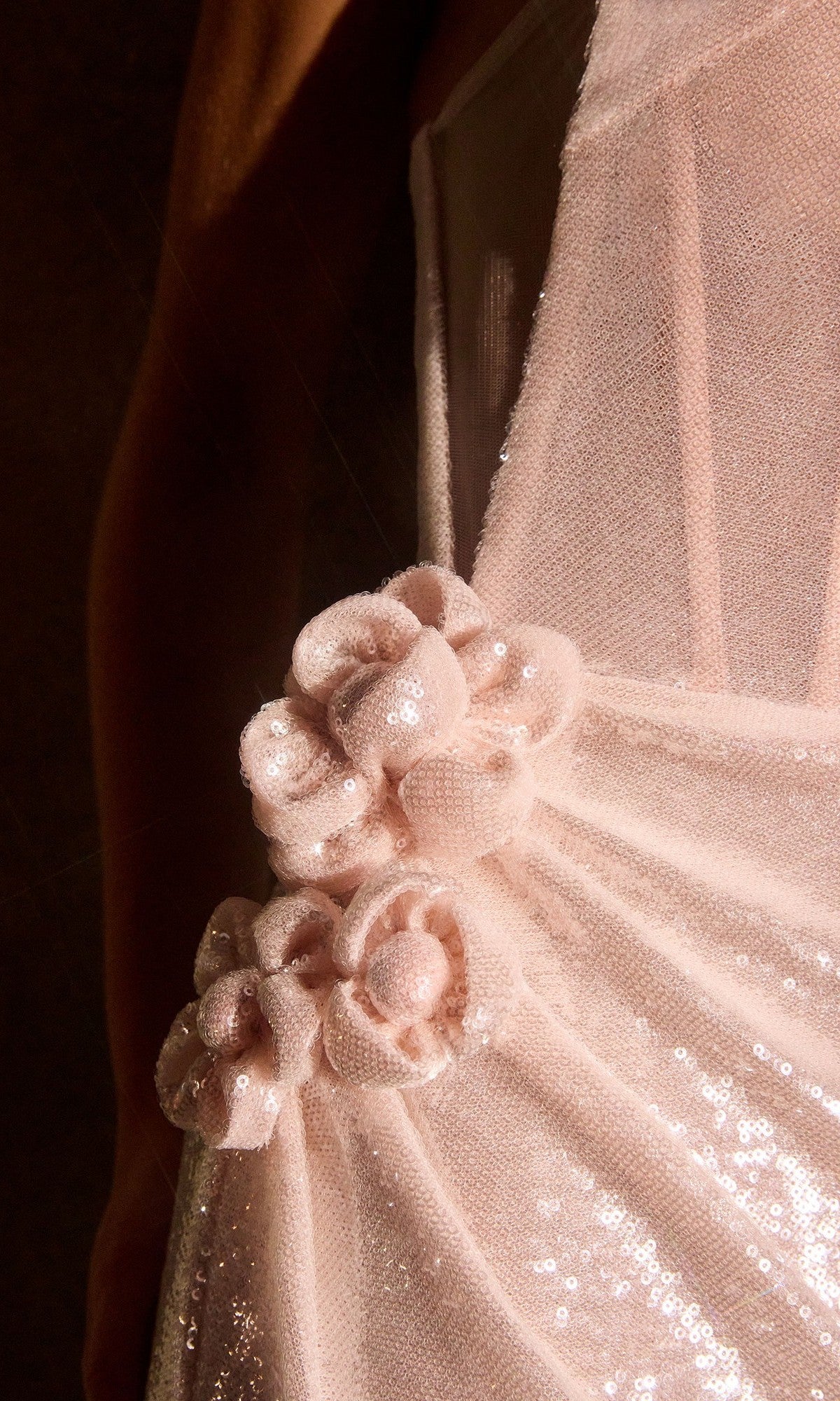 Close-up of the Ladivine J905 long prom dress in light pink sequined fabric, showcasing three elegant fabric flower embellishments at the waist.